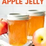 Two Ball Smooth Sided Half Pint Jars of canned apple jelly sit next to fresh apples. A text overlay reads, "How to Can Apple Jelly."