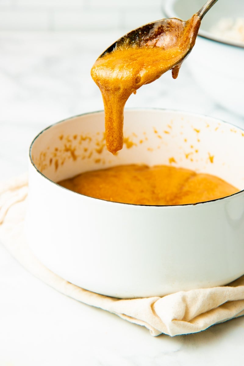 Homemade caramel dripping from a spoon.