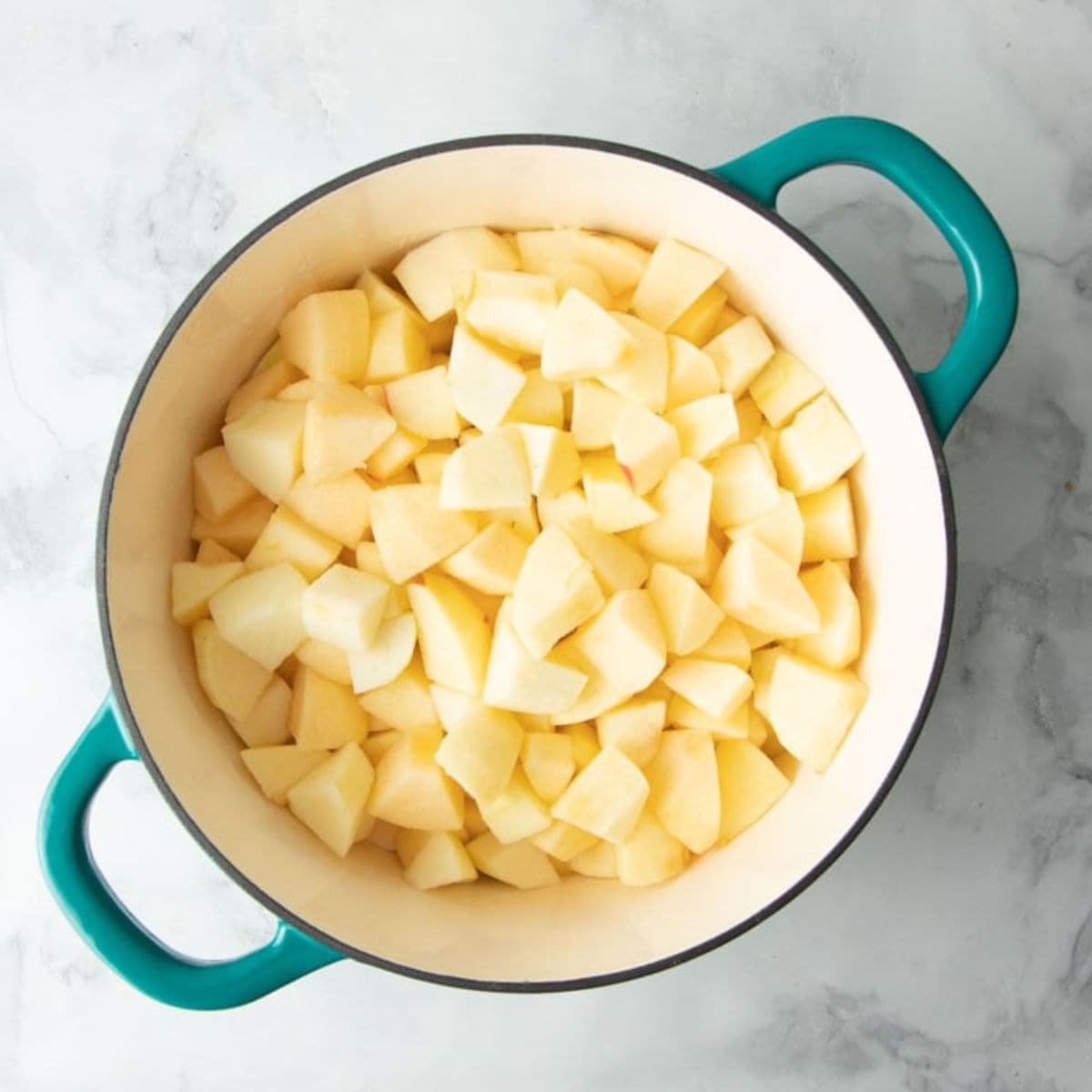 Chunks of apples for applesauce in a Dutch oven pot