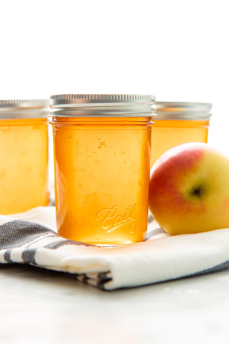 Three Ball Smooth Sided Half Pint Jars filled with finished apple jelly.