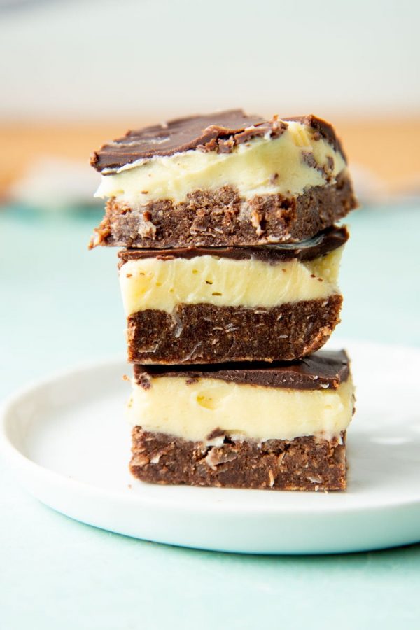 A stack of three canadian nanaimo bars on a plate.