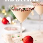 A Christmas martini stands on a kitchen linen surrounded by holiday decor. A text overlay reads, "Sugar Cookie Martini."