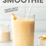 Close-up of orange smoothie in a glass with a glass straw. A text overlay reads, "Dreamy Orange Smoothie. Tastes Like a Creamsicle!"