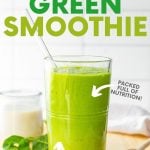 A glass filled with creamy green smoothie and a glass straw on a cutting board with fresh ingredients. A text overlay reads, "Classic Green Smoothie. Packed Full of Nutrition! Tastes Like a Milkshake!"