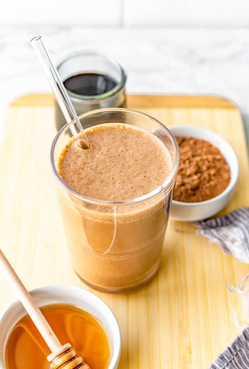 Top view of chocolate coffee smoothie in a glass with a glass straw.