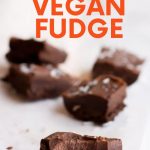 A square of vegan fudge with a bite taken out of it sits in front of four other pieces of fudge. A text overlay reads, "Dark Chocolate Vegan Fudge."