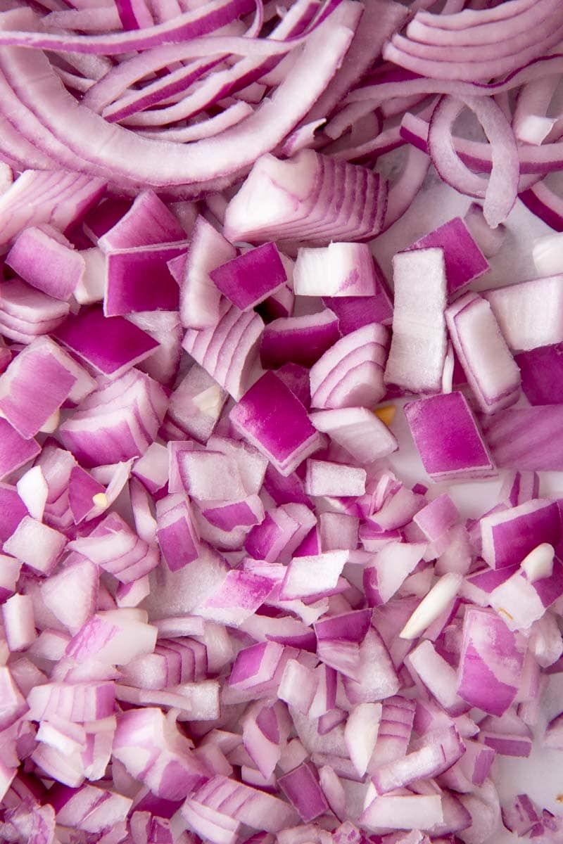 Close-up of sliced, chopped, diced, and minced red onion in a big pile from top to bottom.
