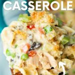 Close up of a scoop of finished casserole on a wooden spoon. A text overlay reads, "The Best! Tuna Noodle Casserole. No Canned Soups!"