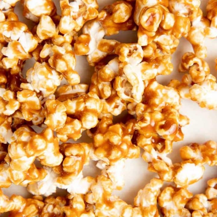 Overhead of caramel popcorn on a white counter.