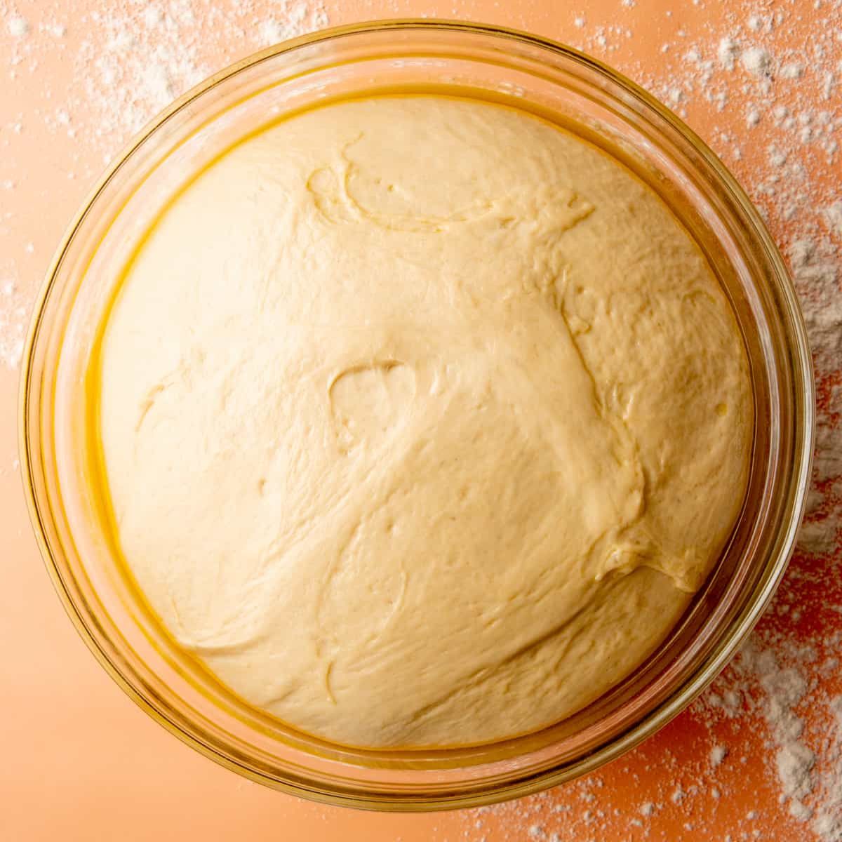 Sandwich bread dough risen in a glass bowl until doubled in size.