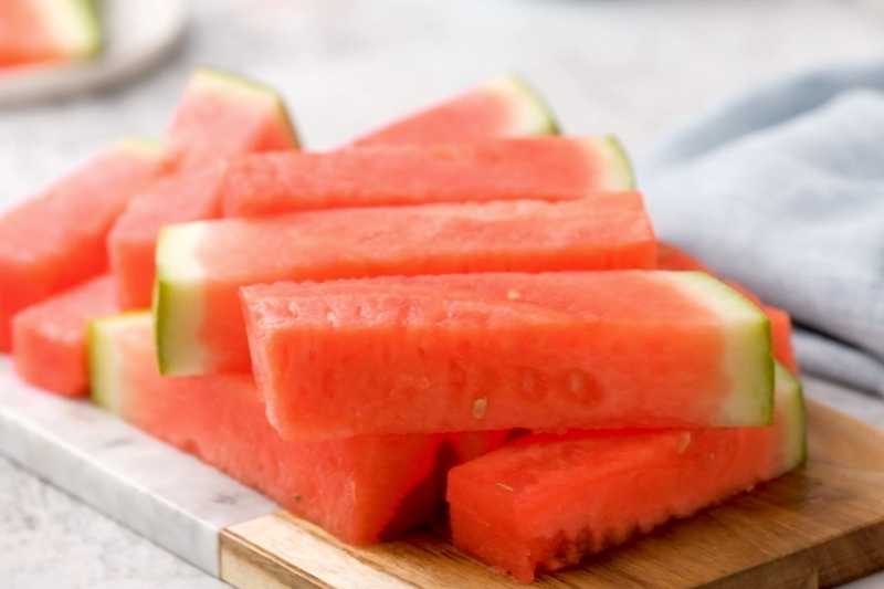 Close up of watermelon sticks on a cutting board.
