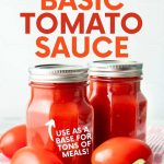 Close-up of two jars of canned tomato sauce with fresh tomatoes and basil. A text overlay reads, "How to Can Basic Tomato Sauce. Use As a Base for Tons of Meals!"
