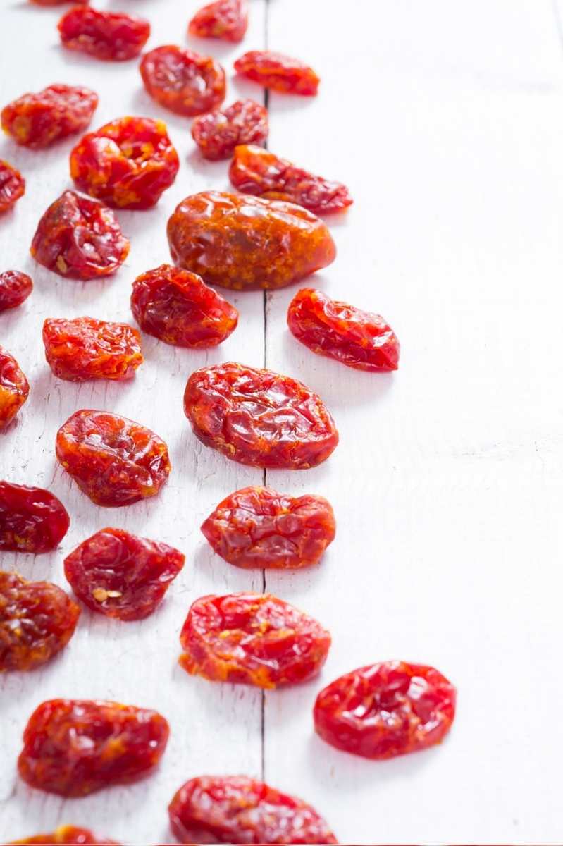 Dried grape tomatoes on a wooden countertop.