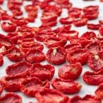 A single layer of dried tomatoes out in the sun.