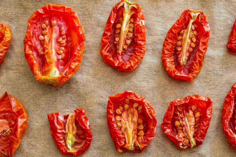 Close-up of sun-dried tomatoes on parchment paper.