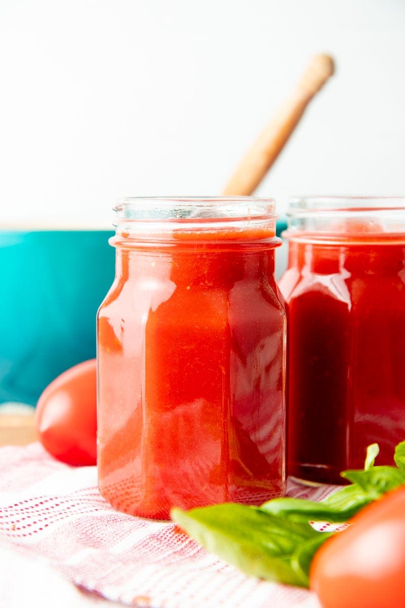 Close-up of two hexagonal jars of homemade tomato sauce.