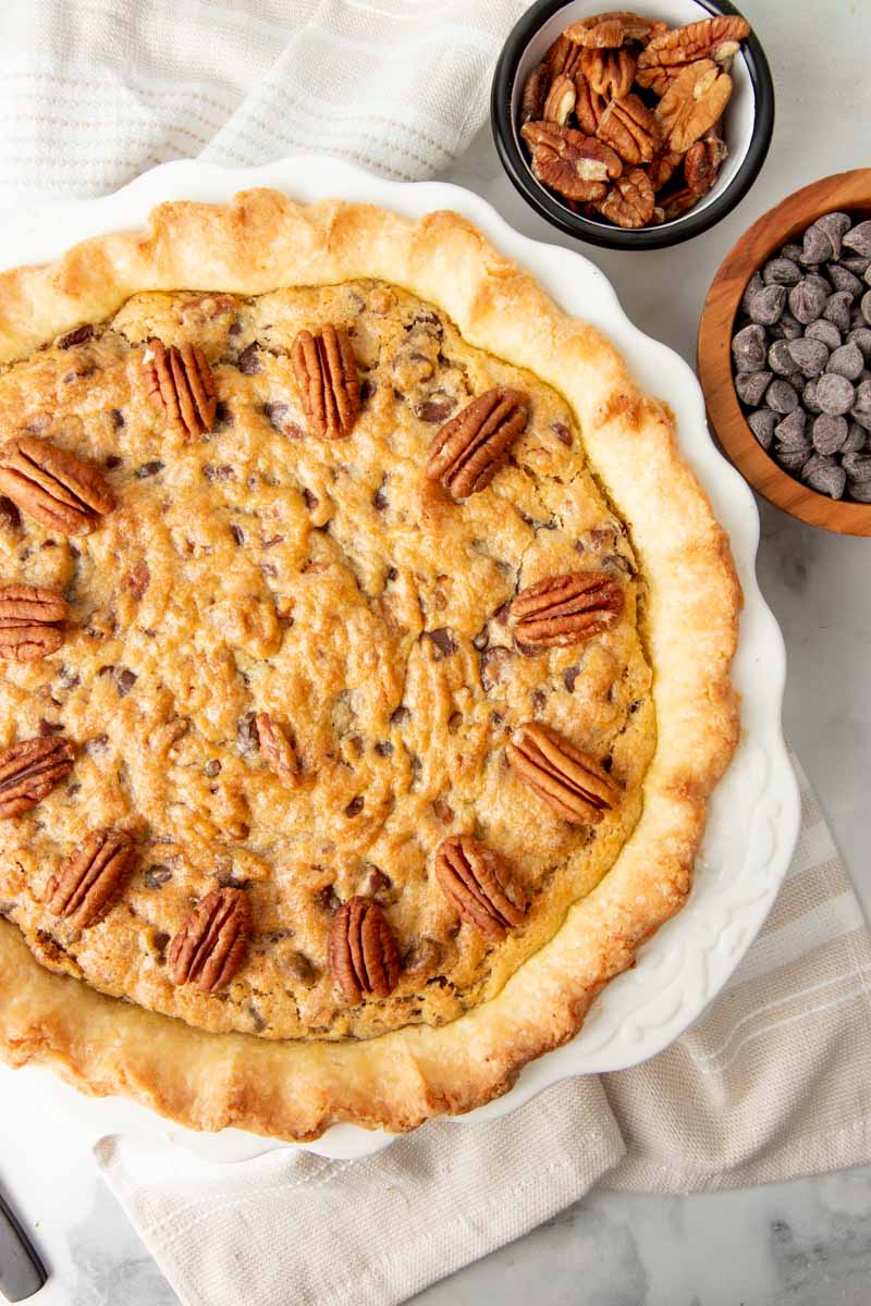 Overhead of a whole chocolate bourbon pecan pie garnished with pecan halves.