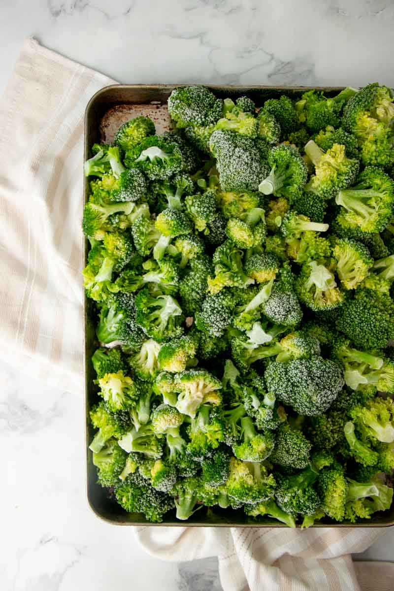 Overhead of a sheet tray filled with frozen broccoli.