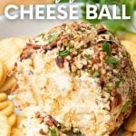 A bite of cheese rests on a spreader alongside crackers for serving. A text overlay reads, "Classic Cheese Ball."