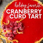 Overhead of cranberry tart on serving platter with candied garnishes on top. A text overlay reads, "Holiday Favorite Cranberry Curd Tart."