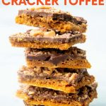Six pieces of homemade saltine toffee stacked high on a counter. A text overlay reads, "Saltine Cracker Toffee."