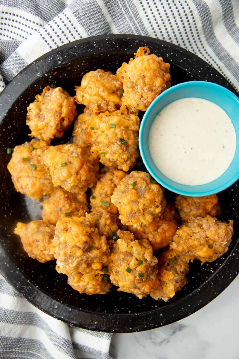 Top view of a holiday appetizer platter of sausage balls and ranch dip.