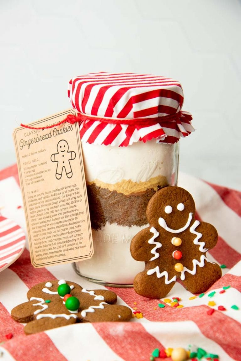 Gingerbread cookie mix in a jar packaged for gifting with colorful fabric, string, and a recipe card.