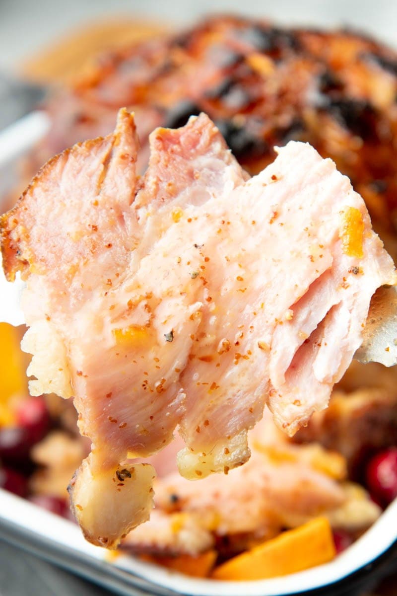 Slice of ham held up on a fork close up.