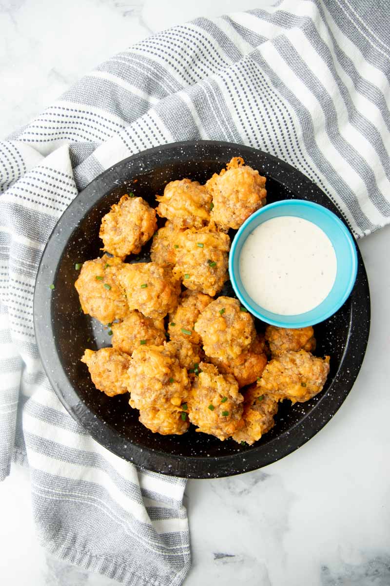 Overhead of a platter of cheesy appetizer bites with ranch dipping sauce.