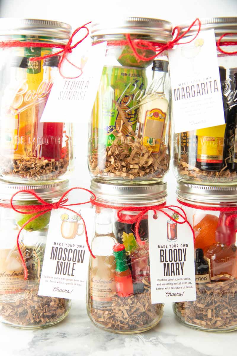 Six cocktail gifts in quart sized mason jars are stacked three on top of three.