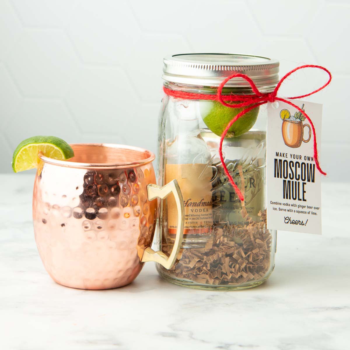 A moscow mule in a copper mug sits next to a cocktail gift kit in a quart sized mason jar.