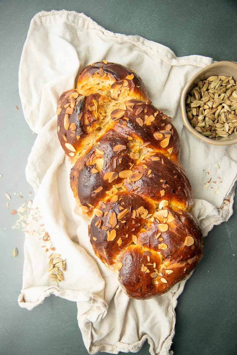 Overhead of a single braided loaf of pulla bread on a white linen.