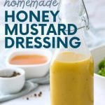 Close view of a glass flip-top bottle filled with creamy honey mustard dressing on a counter. A text overlay reads, "Easy. Healthy. Cheap. Homemade Honey Mustard Dressing."