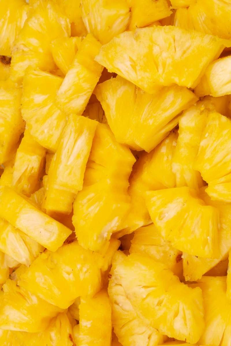 Close view of cut pineapple pieces in a pile.