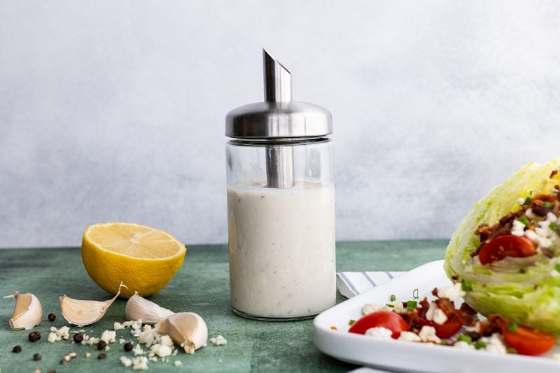 Blue cheese dressing in an easy-pour bottle beside a fresh salad.