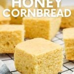 Close view of fluffy squares of buttermilk cornbread on a cooling rack. A text overlay reads, "The Best! Honey Cornbread."