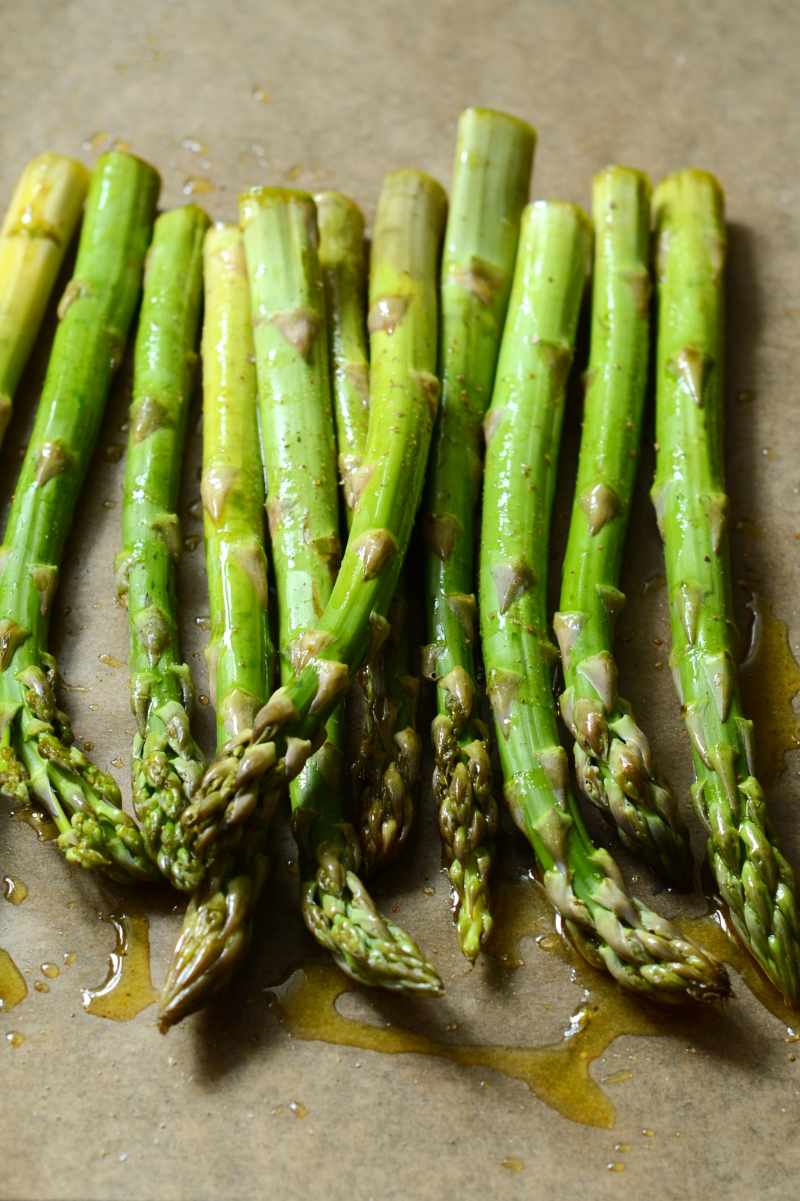Raw asparagus spears, trimmed of woody ends and drizzled with olive oil.
