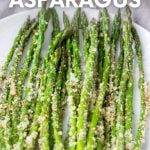 Finished oven roasted parmesan asparagus on a white serving platter. A text overlay reads, "Oven-Roasted Asparagus."