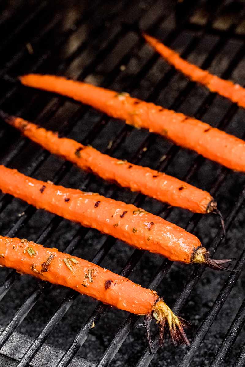 Close view of grill marks on carrots on grill grates.