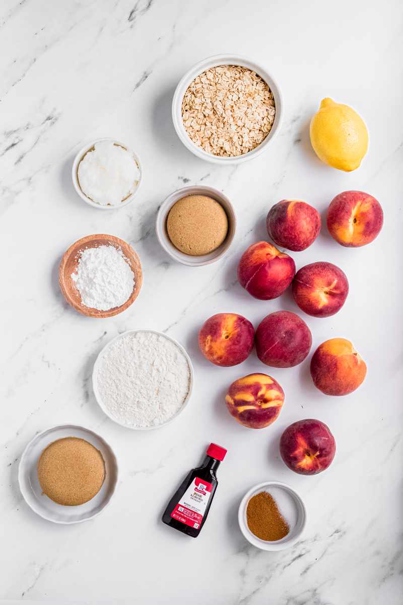 Ingredients for a peach crisp on a marble countertop