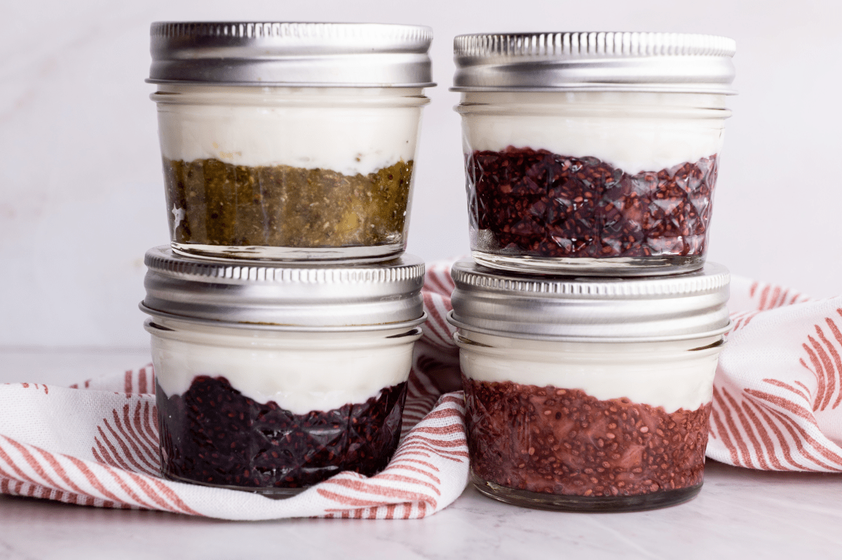 Four quilted jars sit in two columns of two, each filled with a different yogurt flavor