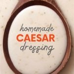 Close view of homemade caesar salad dressing in a wooden spoon. A text overlay reads, "Homemade Caesar Dressing."