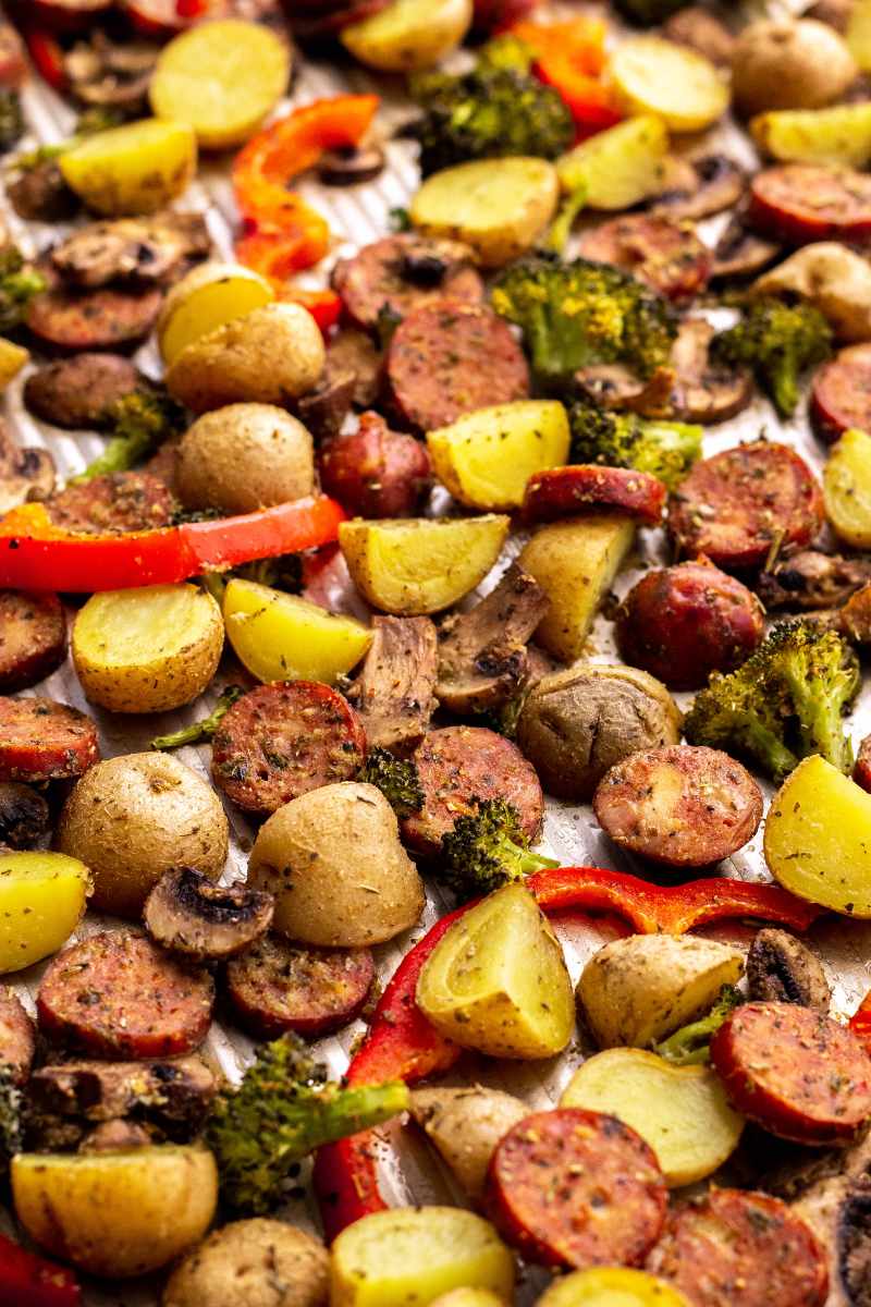 Cooked sausage and veggies on a baking sheet.