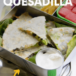 A quesadilla packed into a lunch box with a condiment cup of sour cream. A text overlay reads "Avocado Black Bean Quesadilla"