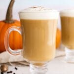Homemade pumpkin spice latte in clear glass mugs in a white kitchen