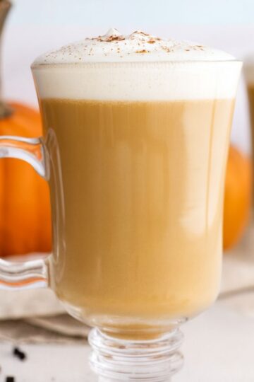 Homemade pumpkin spice latte in clear glass mugs in a white kitchen