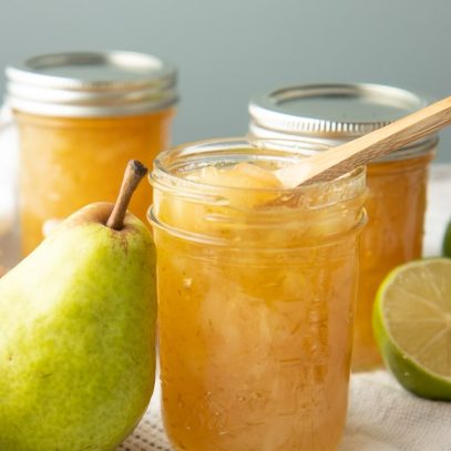 An open jar of preserves stands with a wooden spoon dipped into it.