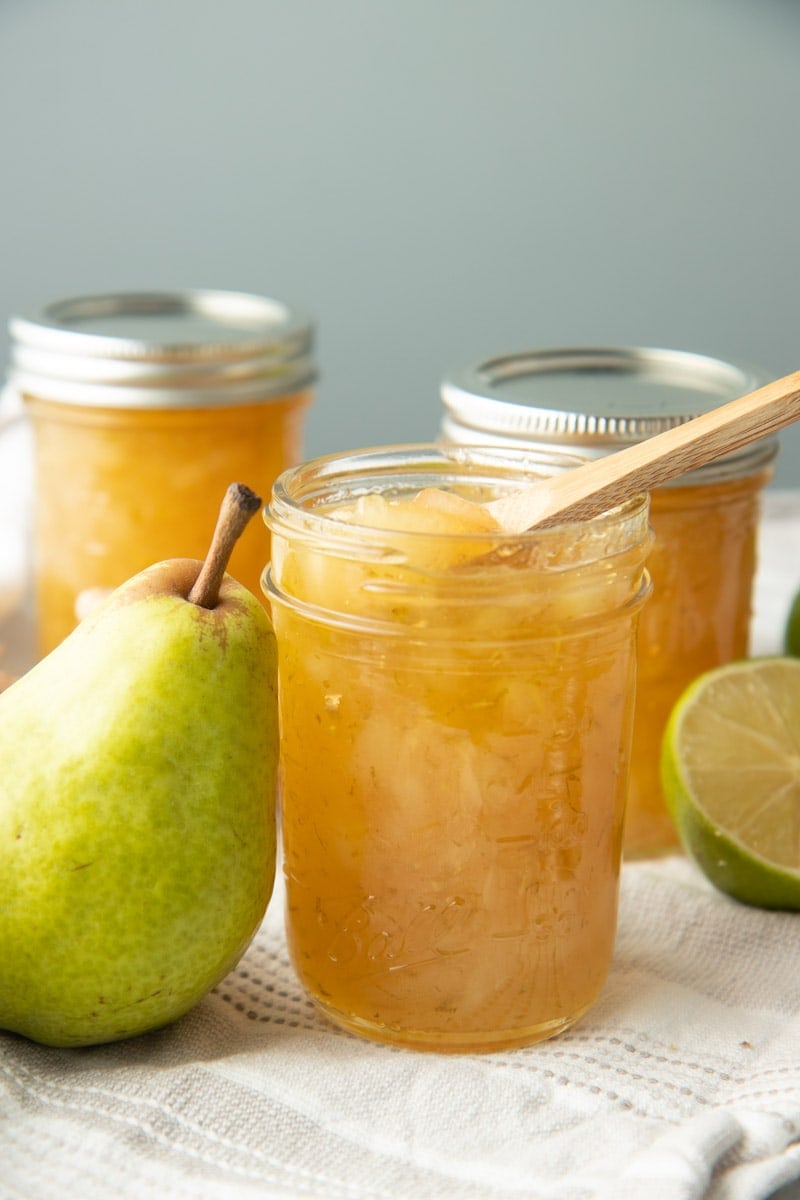 An open jar of preserves stands with a wooden spoon dipped into it.