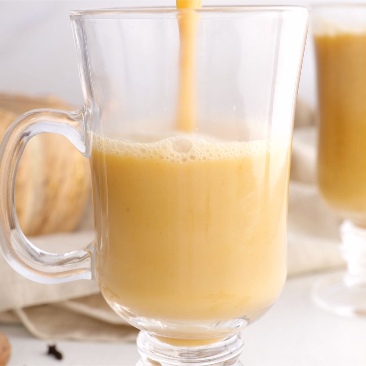 Pouring pumpkin spice latte into a mug