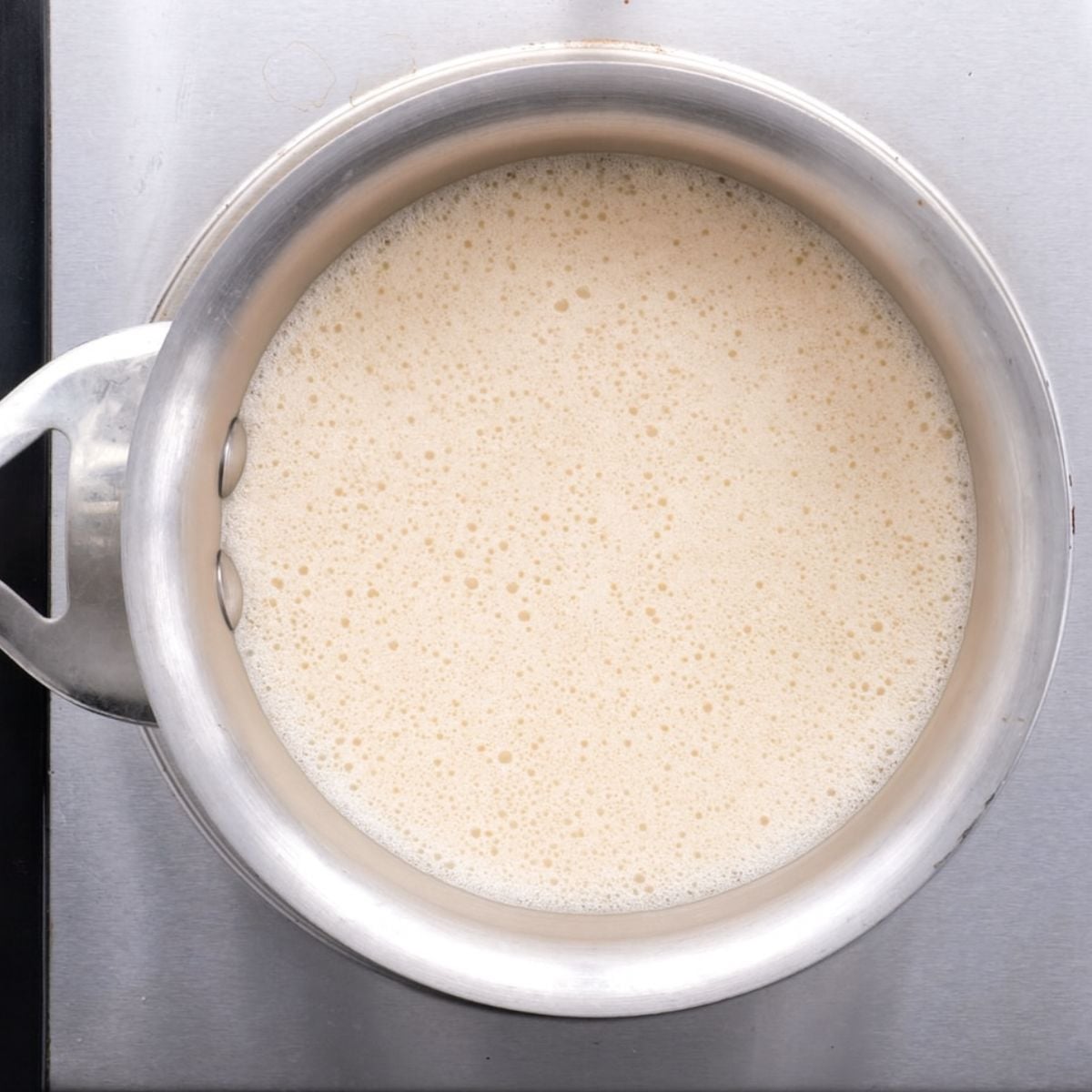 Foamy pumpkin spice latte in a saucepan